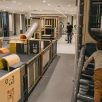 Aire de jeu intérieur sécurisée : enfant sur structure, sol amortissant et surveillance adulte