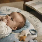 Bébé 4 mois sur tapis d’éveil, repères de développement