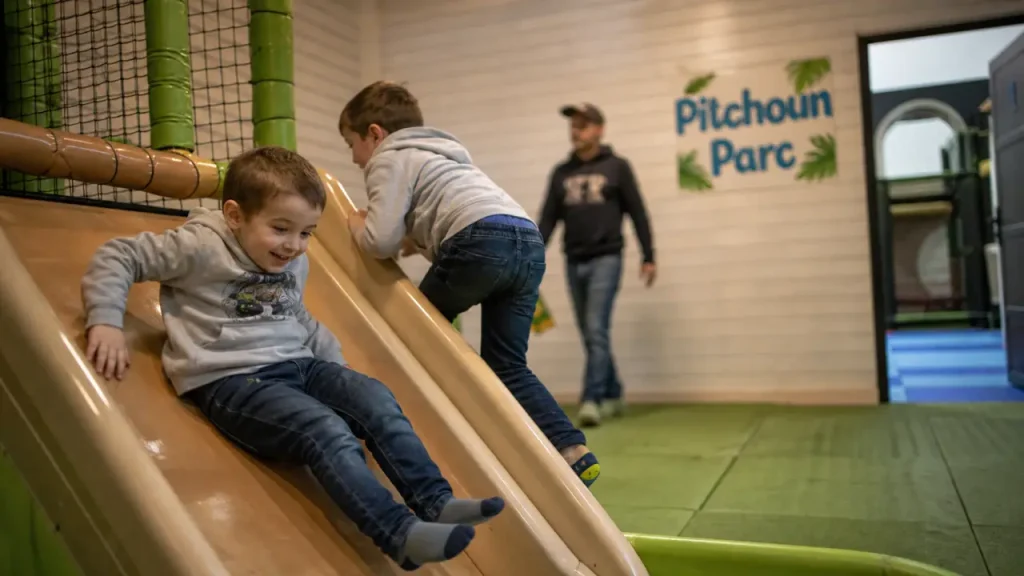 Pitchoune parc à Grenade : enfants sur toboggan en parc couvert