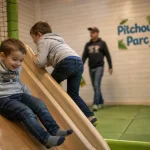 Pitchoune parc à Grenade : enfants sur toboggan en parc couvert